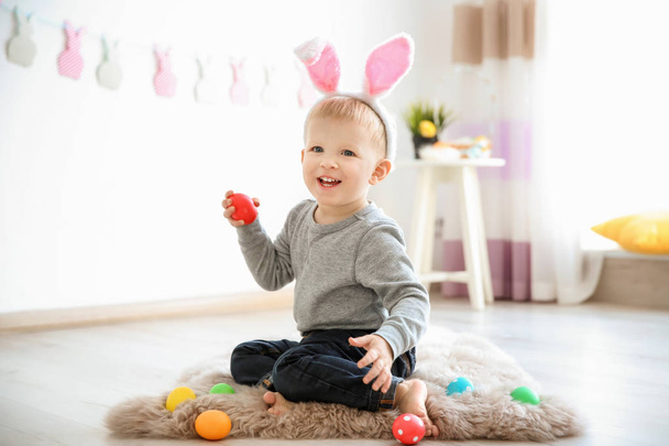 Cute little boy with bunny ears holding Easter egg indoors - Photo, Image