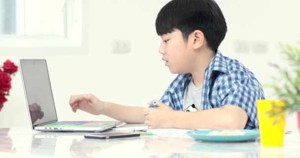 poco asiático preadolescente haciendo tarea en casa con sonrisa cara
 - Imágenes, Vídeo