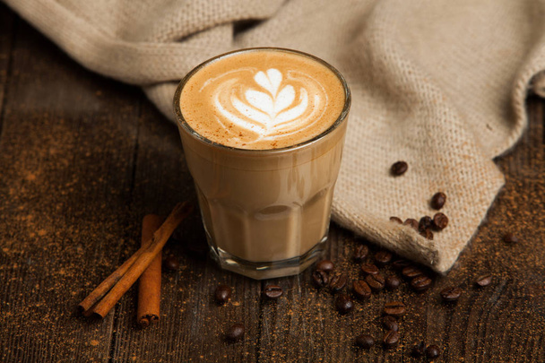 A double latte in a tall latte glass with latte art. - Φωτογραφία, εικόνα