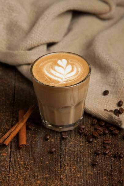 A double latte in a tall latte glass with latte art. - 写真・画像