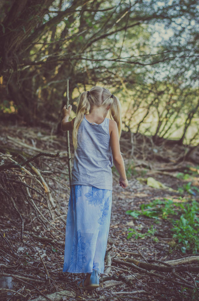 Salaperäinen pieni lapsi kävelee metsässä
 - Valokuva, kuva