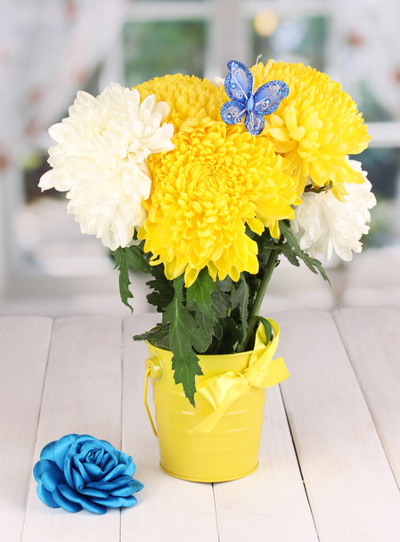 Beautiful chrysanthemum in pail on wooden table on window background - Φωτογραφία, εικόνα