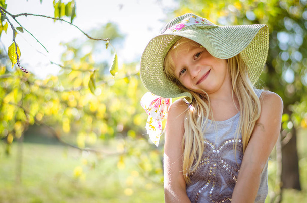 очаровательная улыбающаяся девушка портрет в шляпе в голове в солнечный день в природе
 - Фото, изображение