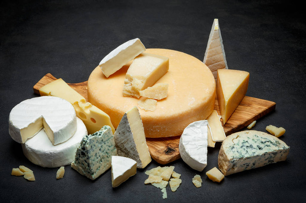 Various types of cheese - parmesan, brie, roquefort, cheddar - Фото, зображення
