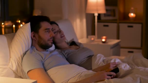 happy couple watching tv in bed at home - Metraje, vídeo