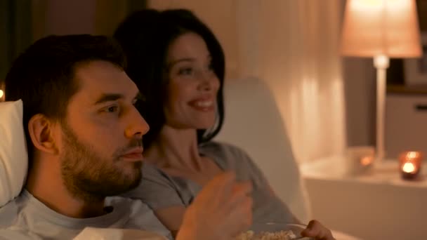 couple with popcorn watching tv at home - Кадри, відео