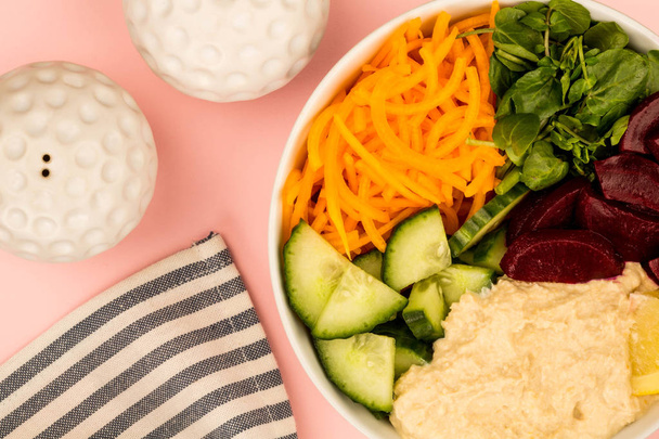 Tigela de comida de salada vegana ou vegetariana com cenouras de húmus de beterraba
 - Foto, Imagem