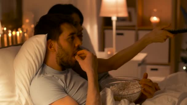 couple with popcorn watching tv at home - Filmagem, Vídeo