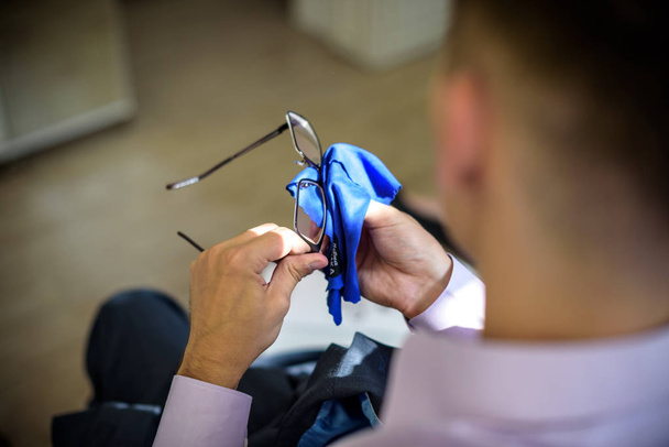 Homme nettoyant les lunettes avec un tissu en microfibre
 - Photo, image
