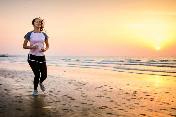 Mädchen läuft bei Sonnenuntergang am Strand - Foto, Bild