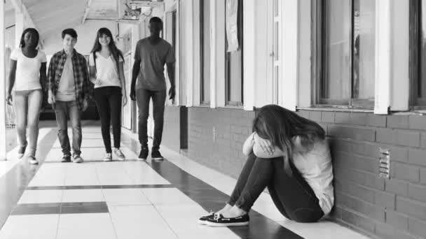 grupo de adolescentes caminando en el pasillo de la escuela e intimidando a una chica sentada en el suelo y llorando
 - Metraje, vídeo