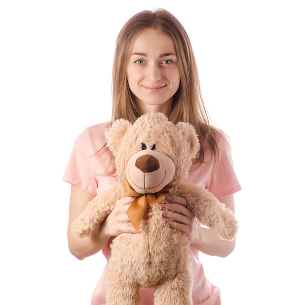 Young beautiful woman in pajamas with toy teddy bear - Фото, изображение