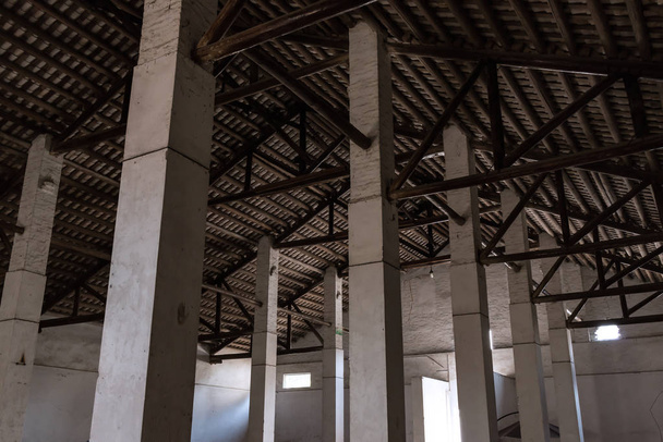 Loft industrial vazio com paredes de cimento nuas e pilares
 - Foto, Imagem