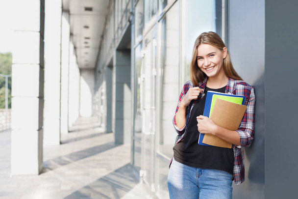 Student girl with books on university background - Photo, Image