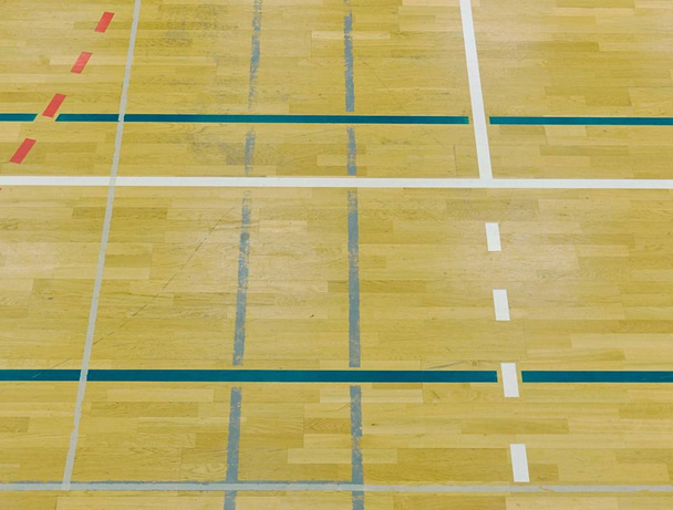 Piso de madeira em salão desportivo com linhas sólidas e pontilhadas. Reflexão da luz
  - Foto, Imagem