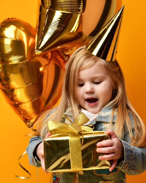 Three years girl toddler kid with gold presents balloons and birthday cap celebrating - Foto, Imagem