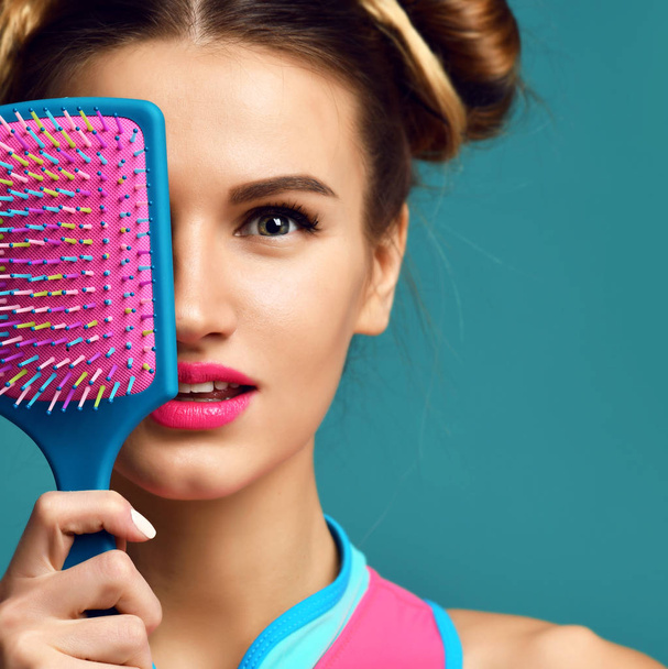Closeup portrait of happy fashion brunette woman close eyes with colorful pink blue yellow big hair comb brush - Zdjęcie, obraz