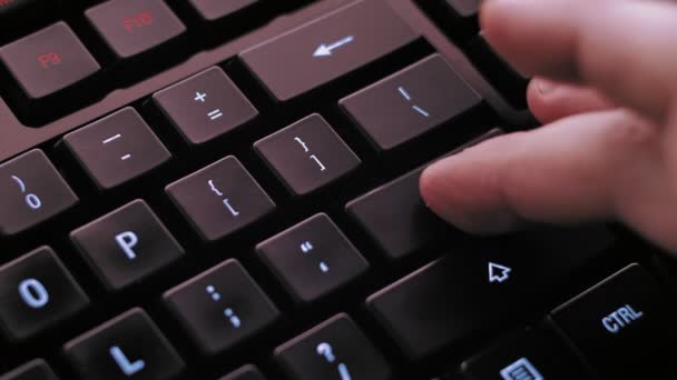 Чоловік натискає клавішу Enter на сучасній освітленій клавіатурі комп'ютера
. - Кадри, відео