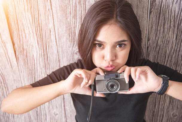 Söpö nuori aasialainen nainen retro kamera valoa. Hipsterikaasut
 - Valokuva, kuva
