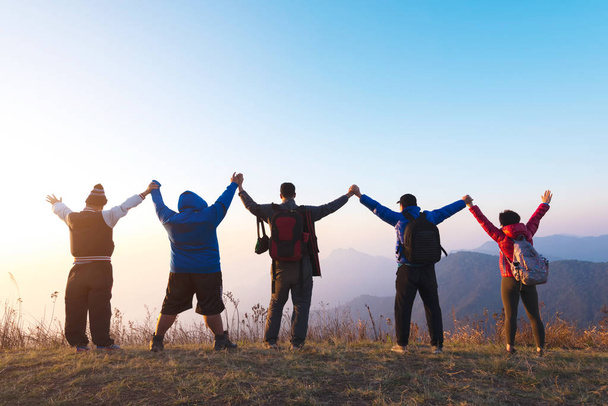 Skupina čtyř lidí, stojí na vrcholu hory v vítěz póze. Koncept úspěch týmu nebo týmové práce. Prostor pro text. Cestovní koncept. - Fotografie, Obrázek