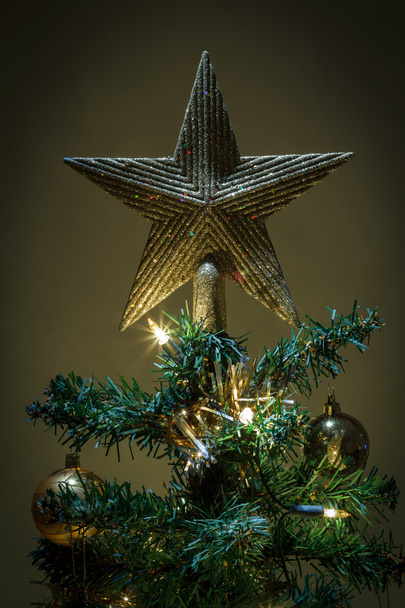 Étoile de Noël sur sapin avec boules jaunes et vertes
 - Photo, image