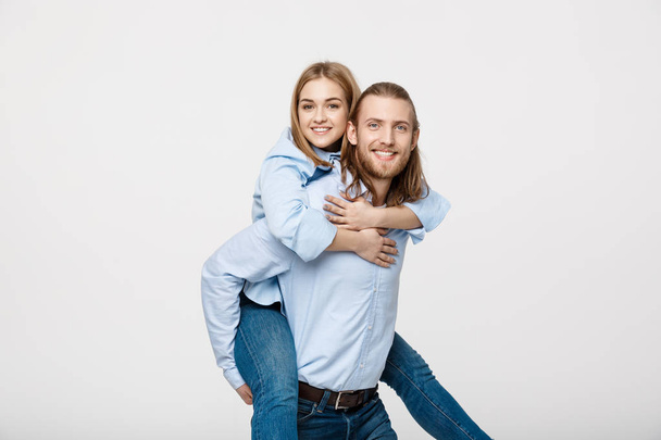 Portrait of smiling man giving happy woman a piggyback ride. - Photo, Image