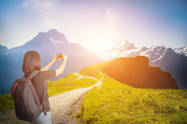 Mulher viajante com mochila montanhismo e tirar uma foto de bela paisagem na Suíça.Viagem conceito de estilo de vida montanha no fundo Verão férias viagem ao ar livre. Vintage filtrado
. - Foto, Imagem