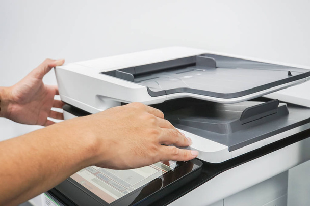 primer plano hombre utilizar impresora multifuncional en la oficina para el trabajo
 - Foto, Imagen