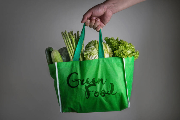 close up a hand holding green grocery bag with Green Food text o - Photo, Image
