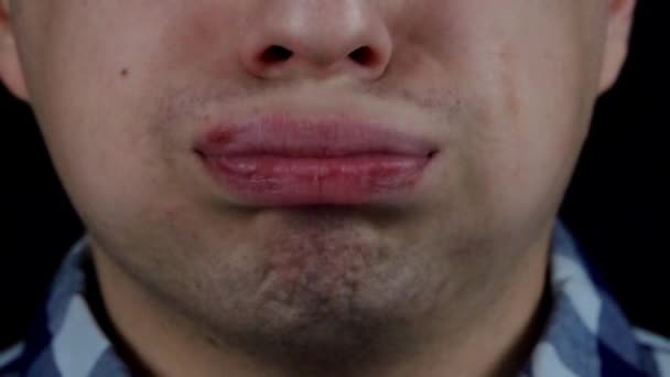 Fiatal férfi rázza a szája a fekete háttér közelről lassítva - Felvétel, videó