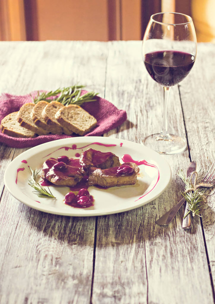 Мясо с соусом и бокалом красного вина
. - Фото, изображение