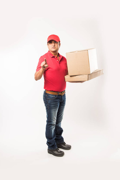 Szállítás fogalma - boldog indiai vagy szállítási férfi egyenruhában piros vagy zöld gyaloglás vagy ugrás ellenőrzése vagy bemutató karton doboz-val másol hely portréja - Fotó, kép