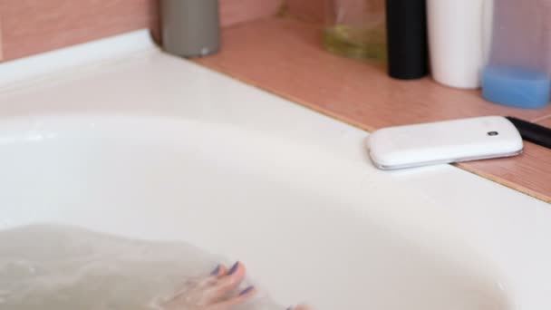 Woman drops her cell phone into the water in the bathroom. Hands and face close-up. - Πλάνα, βίντεο