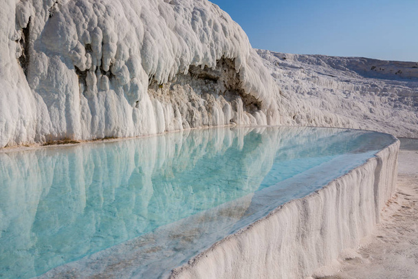 トルコのパムッカレの魅惑的なプール。パムッカレには温泉にはトラバーチン、流れる水によって炭酸塩鉱物の左のテラスが含まれています。サイトは、ユネスコの世界遺産. - 写真・画像