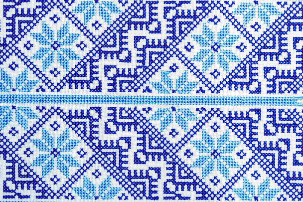 Traditional Ukrainian ornament embroidered with a cross on a linen cloth close-up - Photo, Image