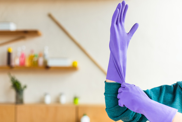 cropped shot of young woman wearing rubber gloves while cleaning house - Foto, Imagem