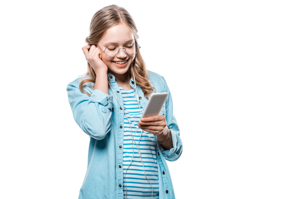 Urocza dziewczyna szczęśliwy słuchawki za pomocą smartfona na białym tle  - Zdjęcie, obraz