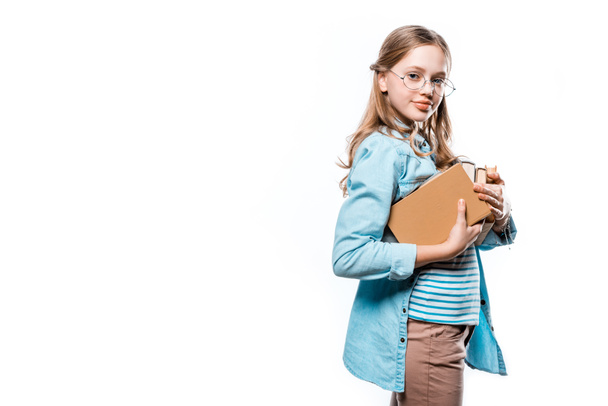 prachtige tienermeisje in brillen houden van boeken en lachend op camera geïsoleerd op wit - Foto, afbeelding