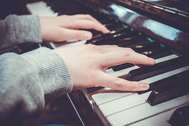 Handen van de musicus op het toetsenbord van een piano - Foto, afbeelding
