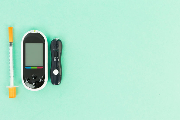 Glukometr a inzulinové stříkačky na zeleném pozadí - Fotografie, Obrázek