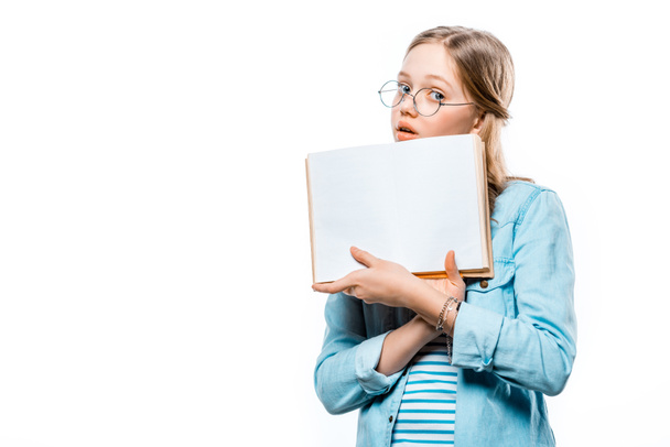 teenage girl in eyeglasses holding blank book and looking at camera isolated on white - 写真・画像