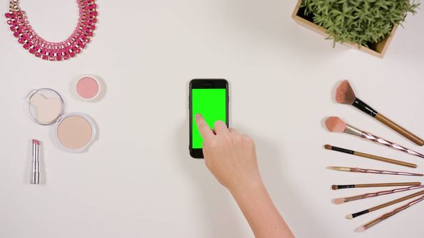 A Finger Touching a Smartphone with a Green Screen - Foto, Imagen