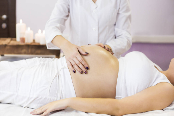 Zwangere vrouw hebben massagebehandeling op spa salon  - Foto, afbeelding