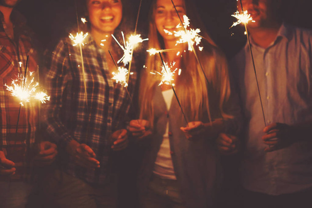 Young people with sparklers having fun on outdoor party - Photo, image