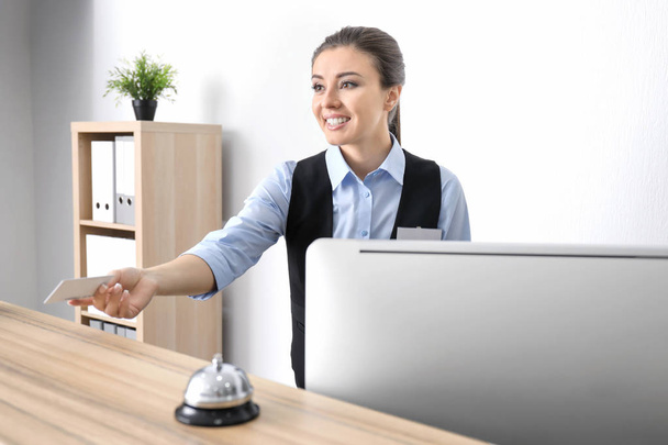 Female receptionist with card in hotel - Photo, Image