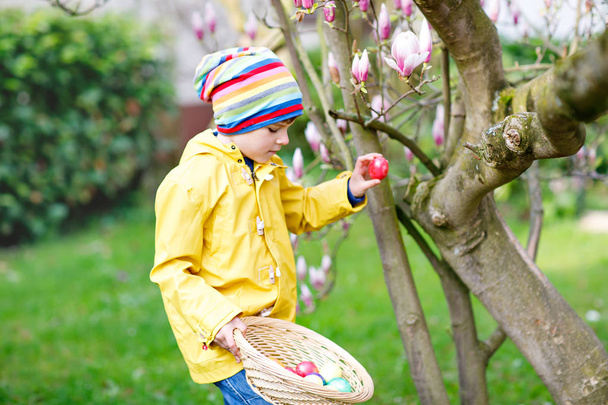 Söpö pieni poika poika tekee muna metsästää pääsiäisenä
. - Valokuva, kuva