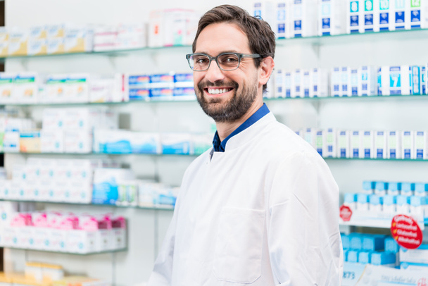 Mannelijke apotheker glimlachend in de apotheek winkel - Foto, afbeelding