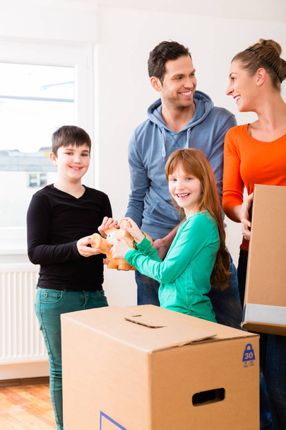 Familia mudándose a un nuevo hogar llevando cajas de embalaje
 - Foto, imagen