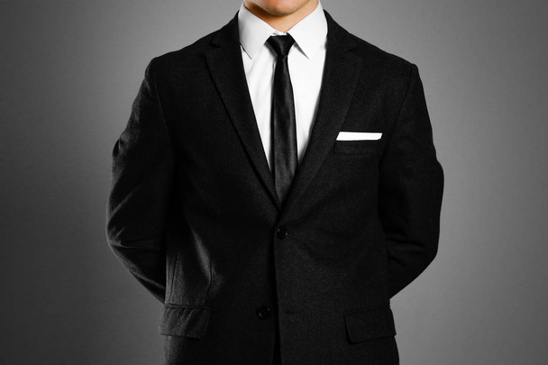 Geschäftsmann im schwarzen Anzug, weißem Hemd und Krawatte. Studiodreh - Foto, Bild