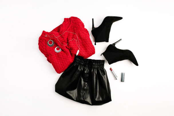 Одяг жіночої моди. Червоний светр, чорна спідниця, взуття та помада. Плоска лежала, зверху жінка дивиться
. - Фото, зображення